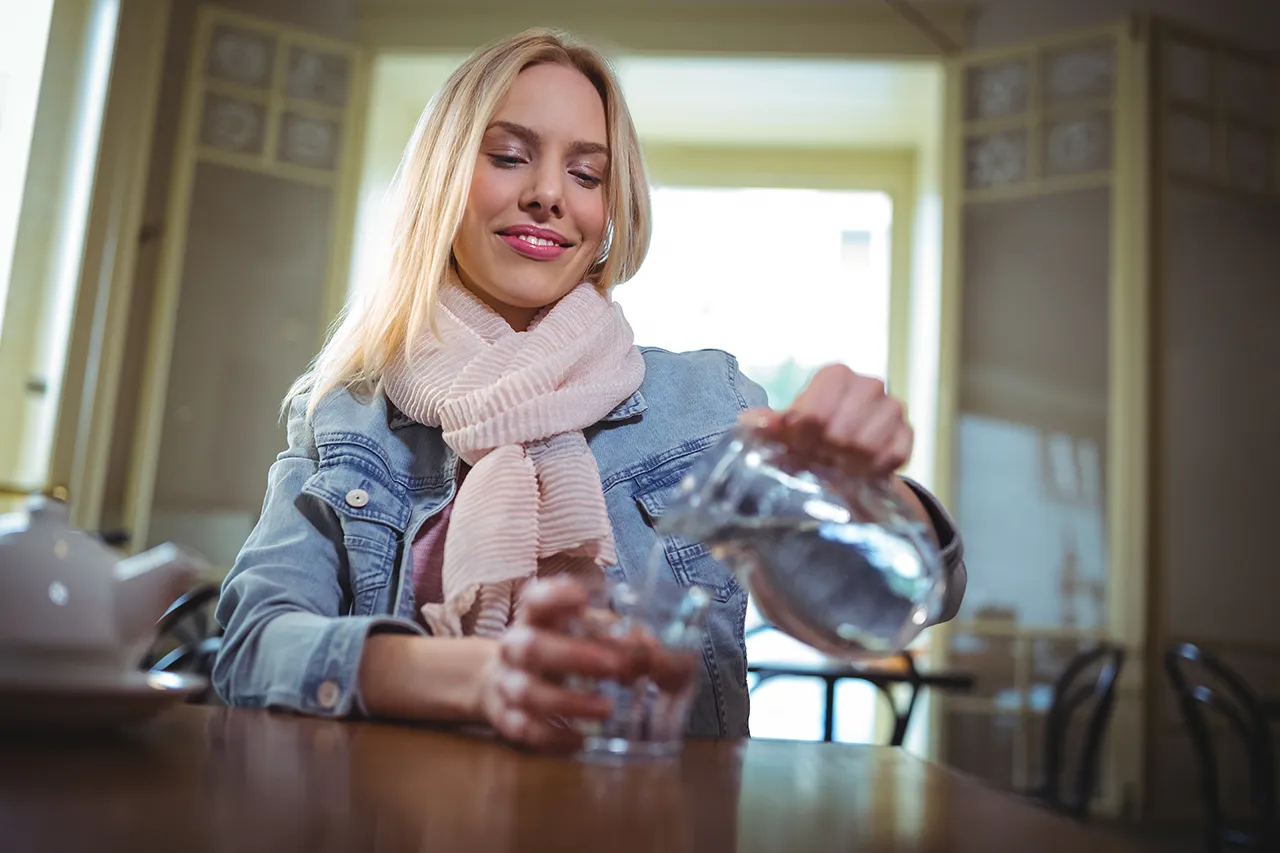 giovane ragazza che versa acqua filtrata e purificata giovane ragazza che versa acqua filtrata e purificata